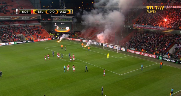 Zápas EL medzi St. Liege a Ajaxom museli prerušiť. Fanúšikovské sektory si začali po sebe hádzať svetlice! (VIDEO)